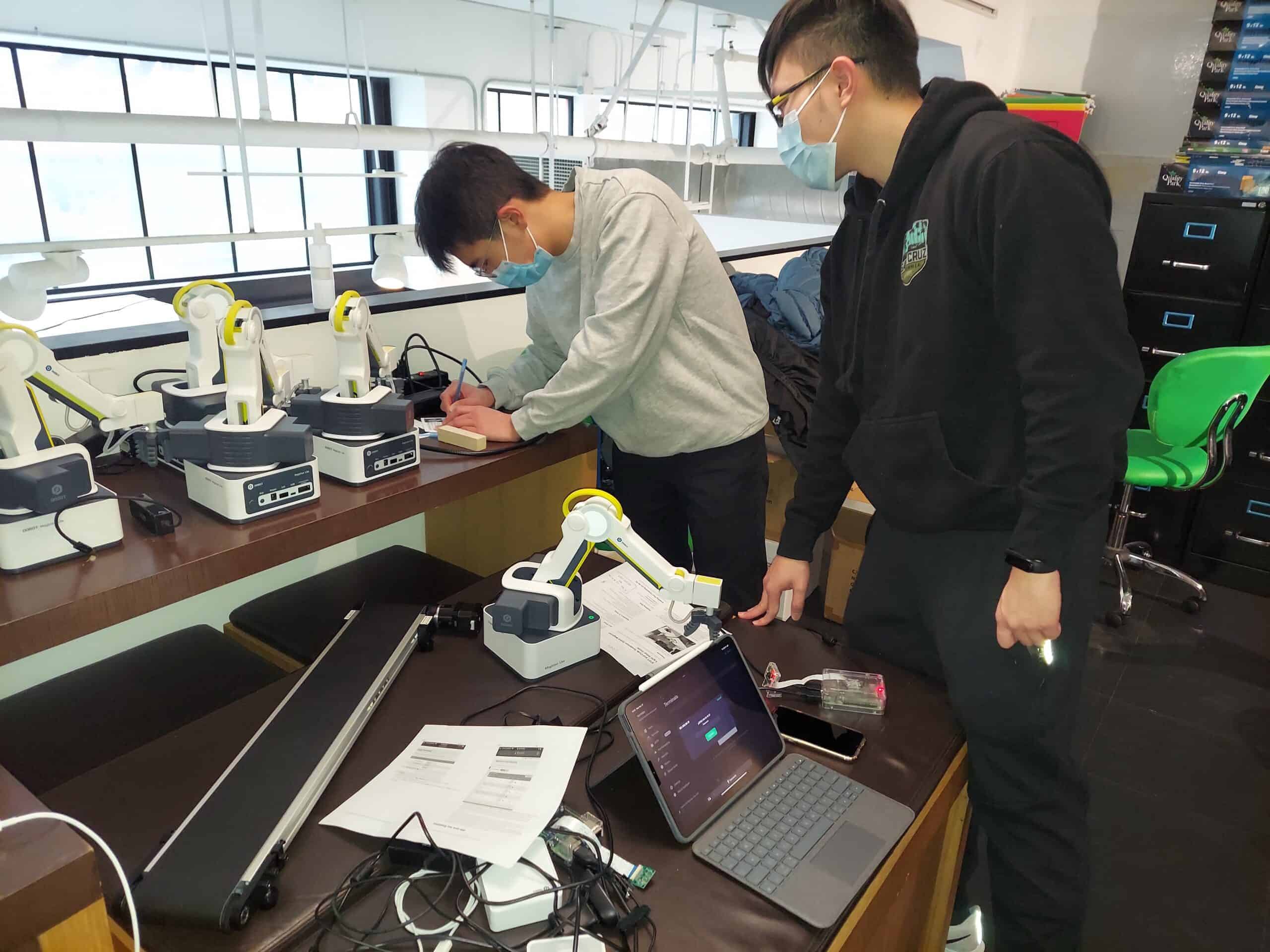 Nick and Ender working on multiple Dobots
